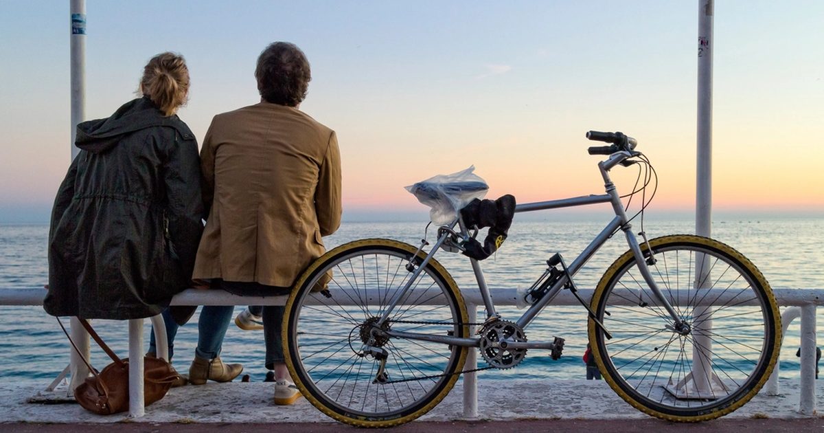 Coppia seduta al tramonto sul lungomare, benessere e fertilita